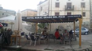 een groep mensen die in een openluchtrestaurant zitten bij Hotel Rural Grado del Pico in Grado del Pico