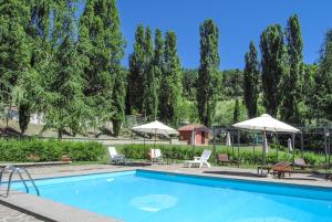 a swimming pool with chairs and umbrellas at Tenuta Del Varco in Varco Sabino