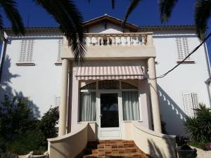 a white house with a white door and stairs at Meublé Tourisme in Marseille