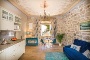 cocina y sala de estar con sofá azul y mesa en Villa Ani apartment Aquamarine, en Dubrovnik