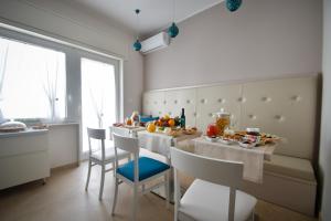 a kitchen with a table and chairs with food on it at B&b Lungomare Otranto in Otranto