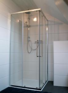 a shower stall with a glass door in a bathroom at Schleusenhof Ferienwohnung in Spieka-Neufeld