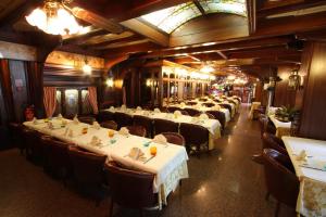 ウーディネにあるホテル アッレ ドゥエ パルメのレストラン内のテーブルと椅子が並ぶ部屋