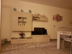 a living room with a television on a cabinet at Villetta nella Baia in Furnari
