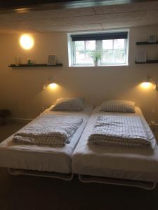 two twin beds in a room with a window at BB-Vesterskov in Nykøbing Falster