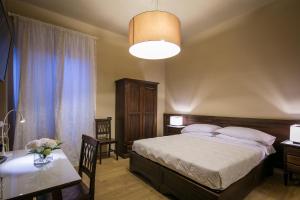 1 dormitorio con 1 cama, 1 mesa y 1 lámpara en Bed and Breakfast Mameli 67, en Montefalco