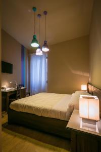 モンテファルコにあるBed and Breakfast Mameli 67のベッドルーム1室(ベッド1台、デスク、2つの照明付)
