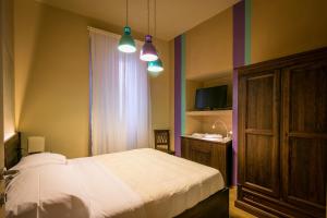1 dormitorio con 1 cama, lavamanos y 2 luces en Bed and Breakfast Mameli 67, en Montefalco