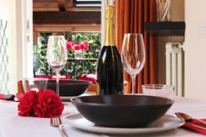 a table with a bottle of wine and two glasses at "Il Cortile" Apartment in Colico