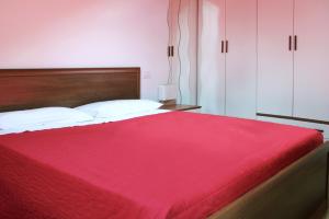 コーリコにある"Il Cortile" Apartmentのベッドルーム(白い枕の大きな赤いベッド付)