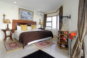 Un dormitorio con una cama grande y una ventana en La Dolce Vita Umhlanga Guesthouse, en Durban