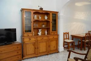 um armário de madeira com uma televisão e uma mesa em Cas Padrins em Can Picafort