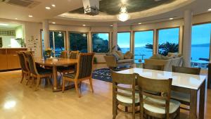 Shirahama Seaside Villa في تانابا: مطبخ وغرفة طعام مع طاولة وكراسي