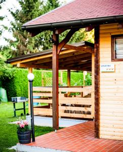a wooden gazebo with a red roof at Apartments Brunarica in Moravske-Toplice