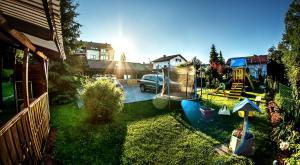 un patio con un parque infantil con un coche y una casa en Apartments Brunarica, en Moravske Toplice