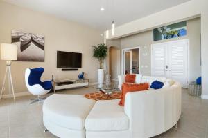 een woonkamer met een witte bank en een tv bij Villa Capricorn in Cape Coral