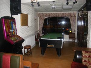 uma sala de bilhar com uma mesa de bilhar e um jogo de vídeo em The Roman Hotel em Blackpool