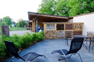 un patio con sillas, una mesa y un edificio en Gaestehaus Herzig en Oberrimsingen