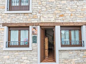 un edificio con dos ventanas y un cartel en él en Casa Rural Antonio, en Vitigudino