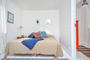 a bedroom with a bed with blue and orange pillows at Rent a House in Brodalen - Lysekil in Brastad