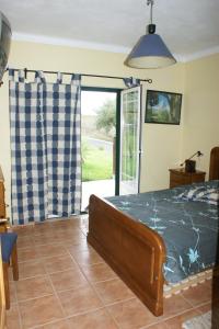 1 dormitorio con 1 cama y puerta corredera de cristal en Quinta da Perdiz Country House en Santarém