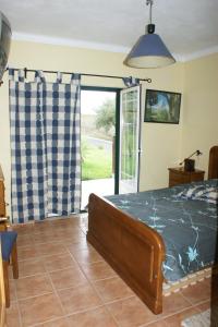 a bedroom with a bed and a sliding glass door at Quinta da Perdiz Country House in Santarém