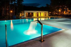 a swimming pool at night with a lit up swimming pool at Apartament Sun & Sand Polanki in Kołobrzeg