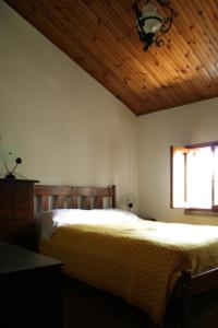 - une chambre avec un lit et un plafond en bois dans l'établissement RioB&B, à Alfero