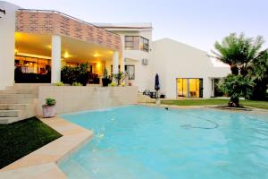 una piscina frente a una casa en La Dolce Vita Umhlanga Guesthouse, en Durban
