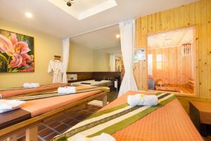 a room with three beds and a mirror at Naina Resort & Spa - SHA Extra Plus in Patong Beach