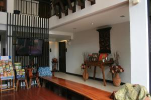 un salon avec une télévision, une table et des chaises dans l'établissement Baan Ing Ping, à Chiang Mai