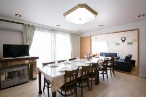a dining room with a long table with chairs at HDO Sumikawa Villa in Sapporo