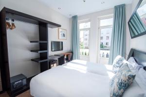 1 dormitorio con cama blanca y ventana en Petit Palace Ruzafa en Valencia