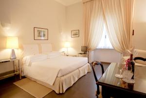 - une chambre avec un lit blanc et une fenêtre dans l'établissement Aldrovandi Residence City Suites, à Rome