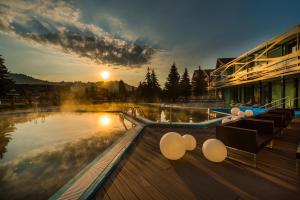 a swimming pool with a view of a lake at Hotel Galeria Thermal Bešeňová in Bešeňová