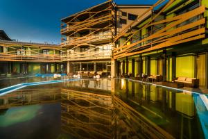 a building with a pool in front of it at Hotel Galeria Thermal Bešeňová in Bešeňová