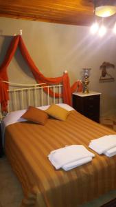 1 dormitorio con 1 cama con toallas en Archontiko Pantou, en Portaria