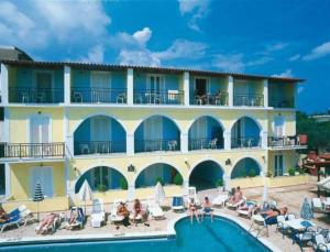 a large building with a swimming pool in front of it at Vossos Hotel Apartments in Laganas