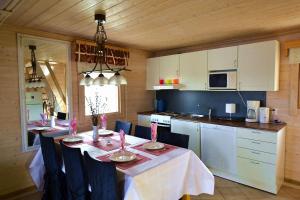 a kitchen with a dining table and a kitchen with white cabinets at Valteri in Enonkoski