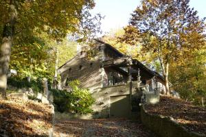 una vieja casa de piedra con un garaje en el bosque en Trumpet House, en Lovaina