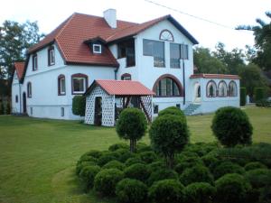 a large white house with a red roof at Hotel Getliin in Saku