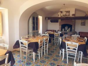 a dining room with tables and chairs and a fireplace at Locanda Marzi in Faicchio