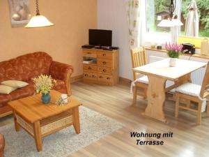 a living room with a couch and a table at Gästehaus Bündge in Kamschlacken