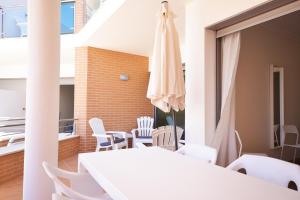 een eetkamer met een witte tafel en stoelen bij Millennium Golf Residences in Vilamoura