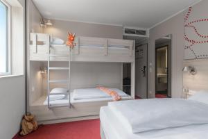 1 Schlafzimmer mit 2 Etagenbetten und 1 Bett in der Unterkunft Serways Hotel Weiskirchen Nord in Rodgau