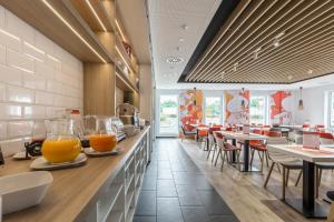 a restaurant with two glasses of orange juice on the counter at Serways Hotel Weiskirchen Nord in Rodgau