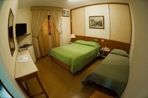 a hotel room with two beds and a mirror at Hotel Thermas Lagoa Santa in Lagoa Santa
