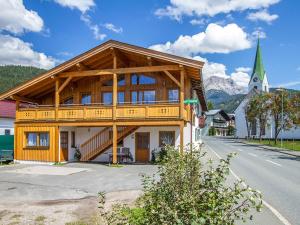 a large wooden building with a mountain in the background at Gertis Ferienwohnung in Hochfilzen