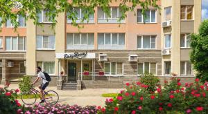 a man riding a bike in front of a building at Easy Room in Nizhny Novgorod