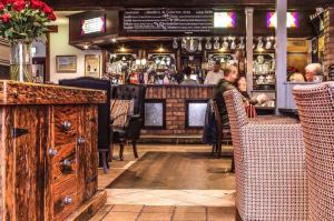 a man sitting at a bar in a restaurant at The Fullerton Arms in Ballintoy